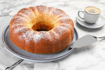 Freshly baked sponge cake, server and coffee on white marble table, closeup