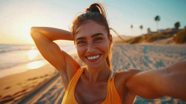 Selfie of a smiling fitness enthusiast flexing her arms at the beach, promoting wellness and motivation for exercise and training on social media