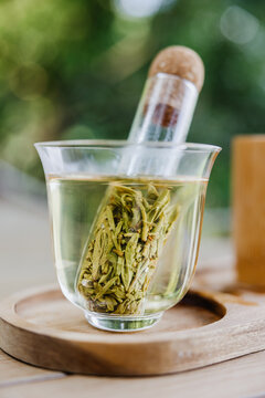 Close-up of green tea brewing in a glass with infuser