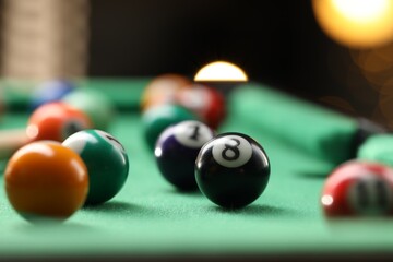 Many colorful billiard balls on green table indoors, closeup