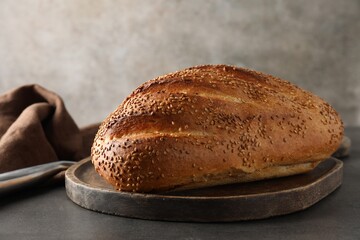 Freshly baked bread with seeds on grey table, closeup