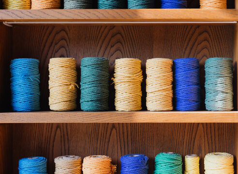 Colorful Spools of Twine on Wooden Shelves