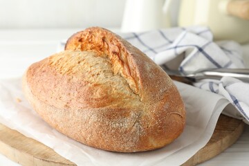Loaf of delicious bread on white wooden table, closeup