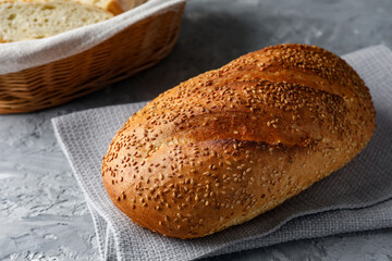 Freshly baked bread with seeds on grey table, closeup