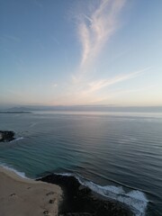 Aerial view of the coastline  with sea views at sunrise with waves crashing onto the beach . Taken in Fuerteventura. 