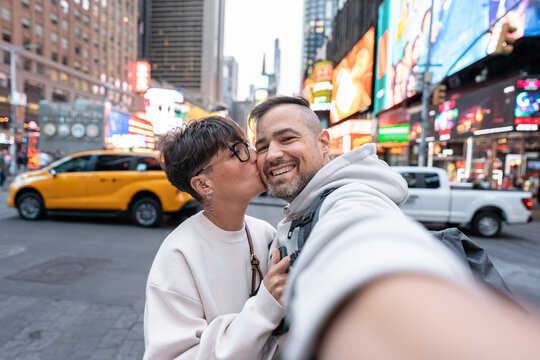 Tourists couple taking selfie in times square, new york city