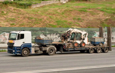 Heavy Lift Construction Equipment Transportation on Open Flatbed Trailer Truck