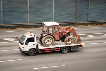 Fototapeta premium Transporting Heavy Agricultural Machinery on a Tow Truck