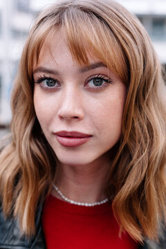 Close-up portrait of a woman with wavy hair and striking blue eyes