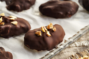 Homemade healthy sweets made of greek yogurt, nut butter and maple syrup coated in chocolate and sprinkled with hazelnuts