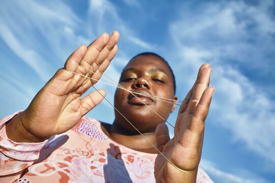 A joyful moment of string art under a bright sky
