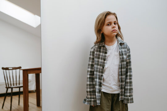 A Young Child Stands Alone in a Quiet Room