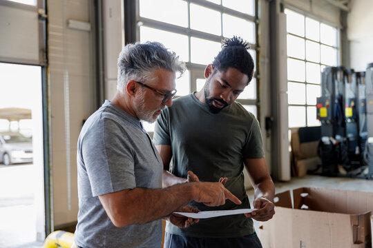 Coworkers discussing over document in automobile industry