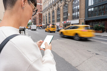 Woman using smartphone app ordering taxi cab in new york city