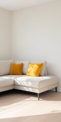 A white couch with yellow pillows sits in a room with a white wall. The couch is positioned in a corner, and the pillows are arranged in a way that creates a cozy and inviting atmosphere