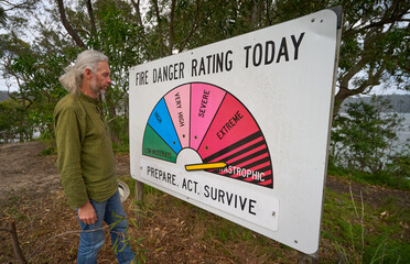 Man reads Fire Danger sign, outback Australia - catastrophic risk