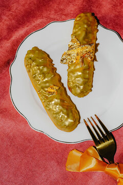 Golden chocolate eclairs on plate