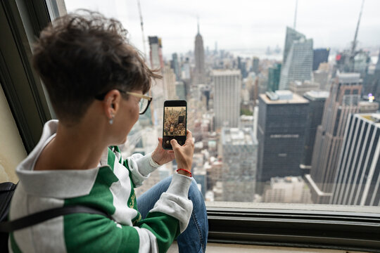 Tourist taking pictures of new york city skyline