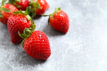 Delicious fresh red strawberries in a bowl on a gray background
