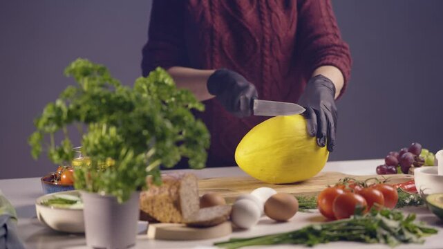 Krojenie ż&oacute;łtego melona na drewnianej desce w kuchni &ndash; zdrowe owoce i świeże składniki w diecie