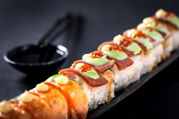 Japanese cuisine. Sushi rolls on a black platter