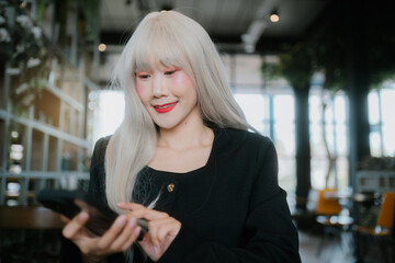 woman with long white hair smiles while using smartphone in e