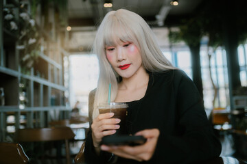 woman with long white hair enjoys drink in cozy e