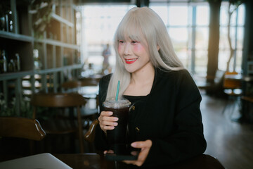 woman with long white hair enjoys drink in cozy e