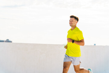 Runner enjoying a morning jog on a rooftop in an urban setting under a clear sky