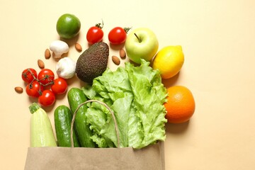 Paper bag, vegetables and fruits on color background, space for text