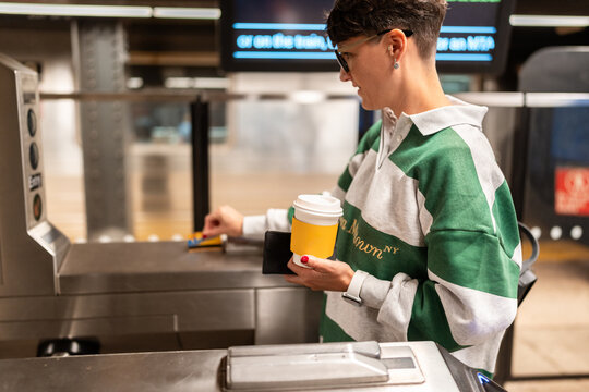 Woman using metrocard entering new york city subway station