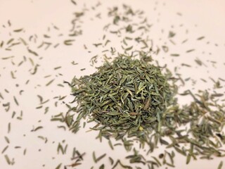 Pieces of dried thyme on a pink background.