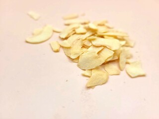 Dried pieces of sliced garlic on a bright background.