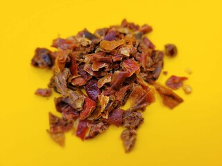 Raw portion of dried paprika on a yellow background.