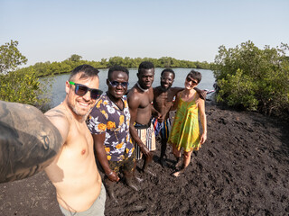 Tourists taking selfie with locals in the sine-saloum delta, senegal
