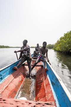 Fishermen rowing traditional pirogue in the sine-saloum delta, senegal