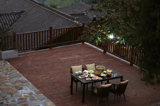 Dining table and full of delicious food in the courtyard at night