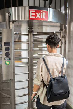 Woman exiting subway station through turnstile in manhattan, new york