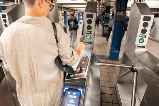 Tourist paying with omny system at turnstile in nyc subway