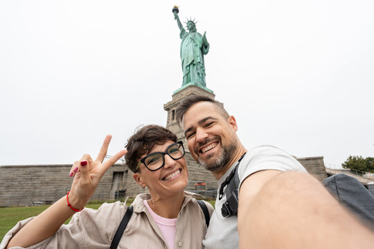 Tourists taking selfie with statue of liberty in new york city