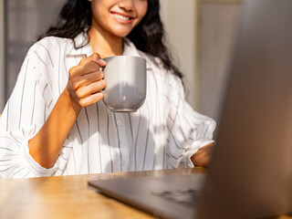 Woman Enjoying Coffee While Working on Laptop at Home