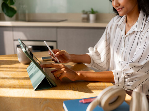 Woman Using Tablet and Smartphone in Home Office Setting