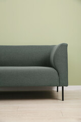 One stylish sofa near green wall indoors