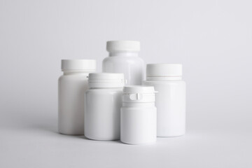 Many plastic medical bottles on white background