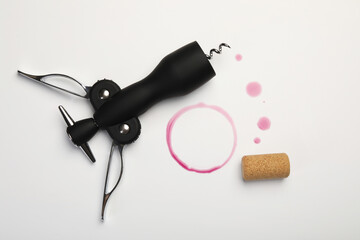 Obraz premium Wing corkscrew, cork and red wine stains on white background, top view