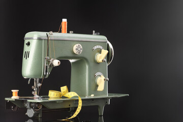 Professional sewing machine and measuring tape on black background, space for text