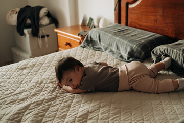 Baby 8 months old on bed in bedroom