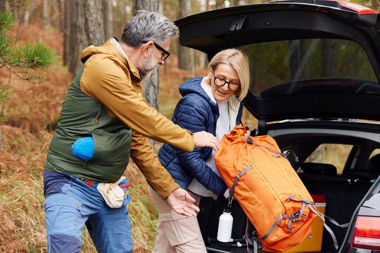 Couple takes camping things out of the trunk