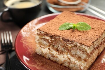 Delicious tiramisu with mint on dark table, closeup
