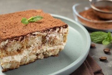 Piece of tasty tiramisu on grey table, closeup